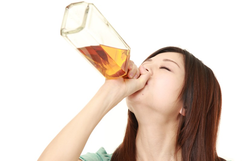 Woman downing alcohol